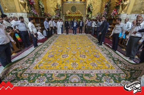 A believer presents a precious carpet to the shrine of Aba al-Fadl al-Abbas (PBUH).